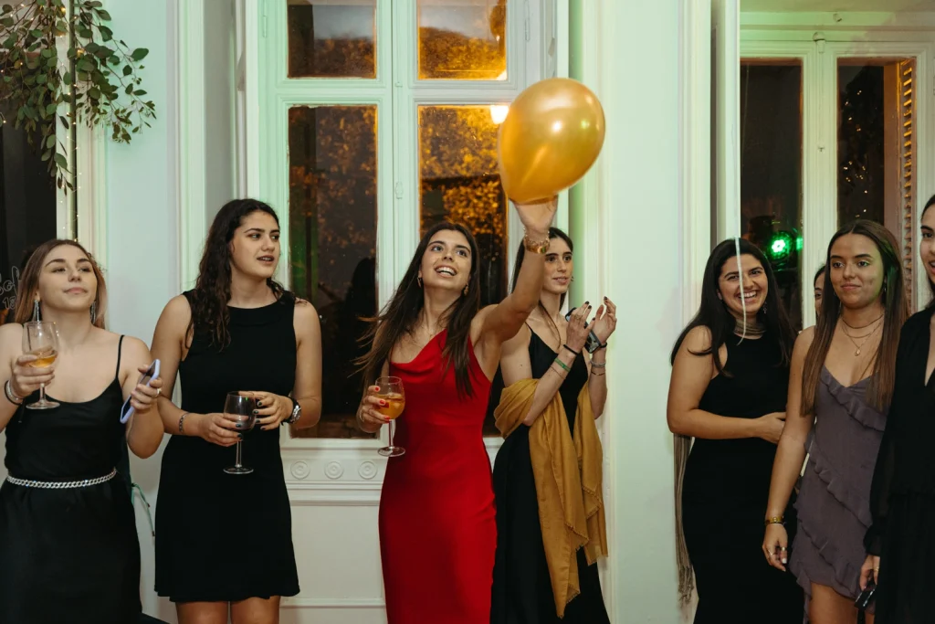 A joyful moment as friends celebrate a birthday indoors, with laughter, balloons, and good vibes in Portugal