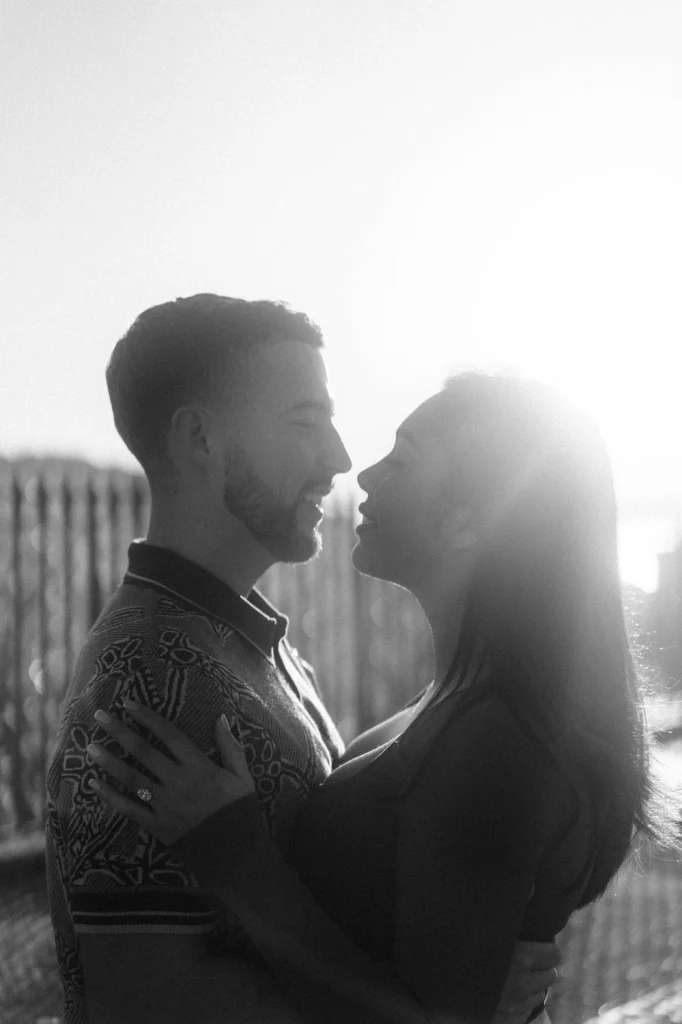 A timeless black and white portrait of a couple sharing a quiet, intimate moment at sunset