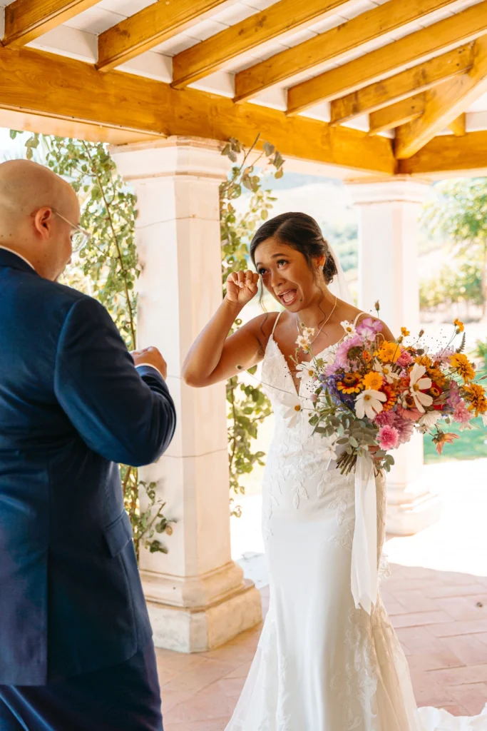 Bride wiping away tears while reading her wedding vows during a first-look moment at Quinta de Sant'Ana.