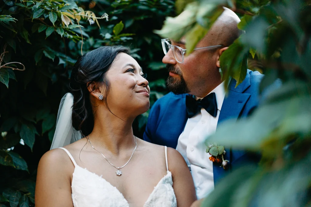 A romantic moment between Sarah and Jason, surrounded by lush greenery on their wedding day in Portugal.