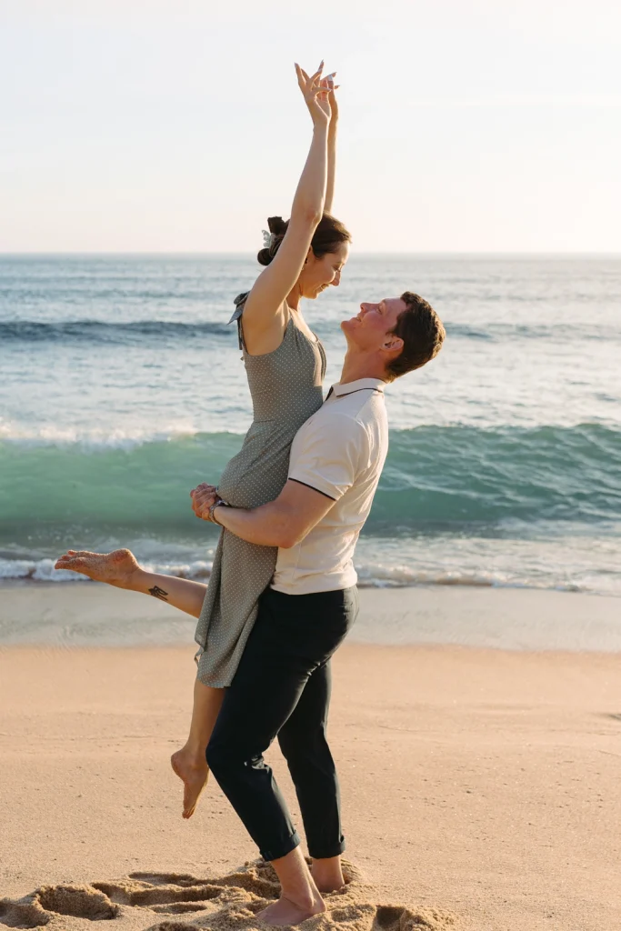 A beautiful couple standing together on a rugged coastline, capturing a timeless romantic moment.