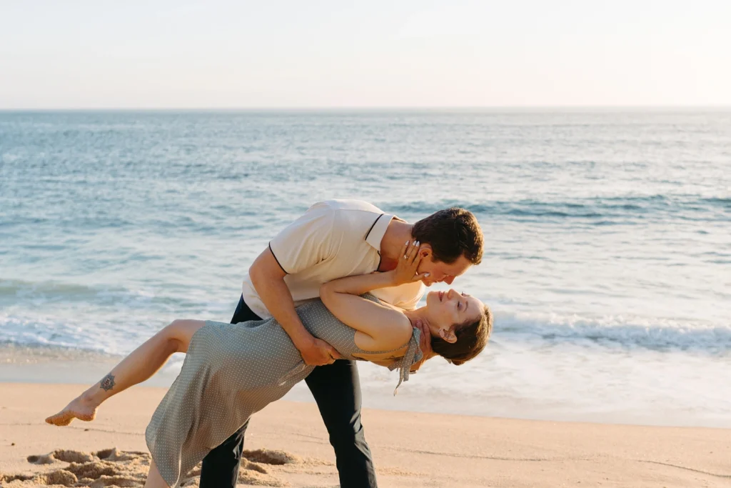 A couple walking hand in hand along a scenic coastal cliff, enjoying a serene and loving moment.