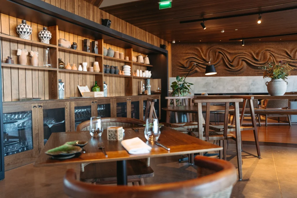 A refined dining space with wooden interiors, artistic decor, and cozy ambiance in a luxury venue in Ericeira