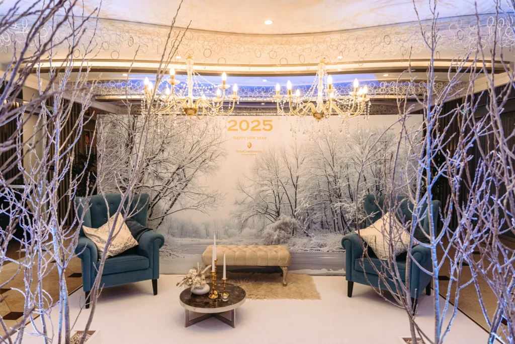 Luxurious winter-themed event setup with cozy armchairs, chandeliers, and a snowy backdrop, creating a warm and elegant atmosphere in Cascais