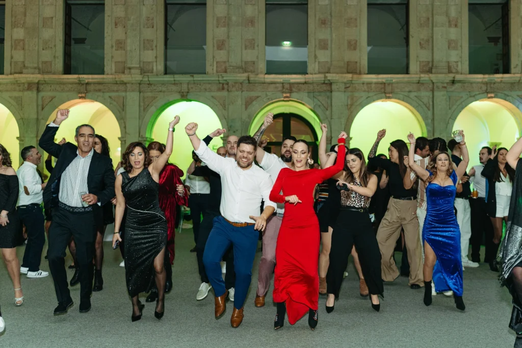 Guests dancing energetically at a corporate gala, dressed in elegant attire, celebrating a successful event