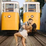 A romantic engagement session in Lisbon, featuring a couple posing with the city’s famous yellow trams.