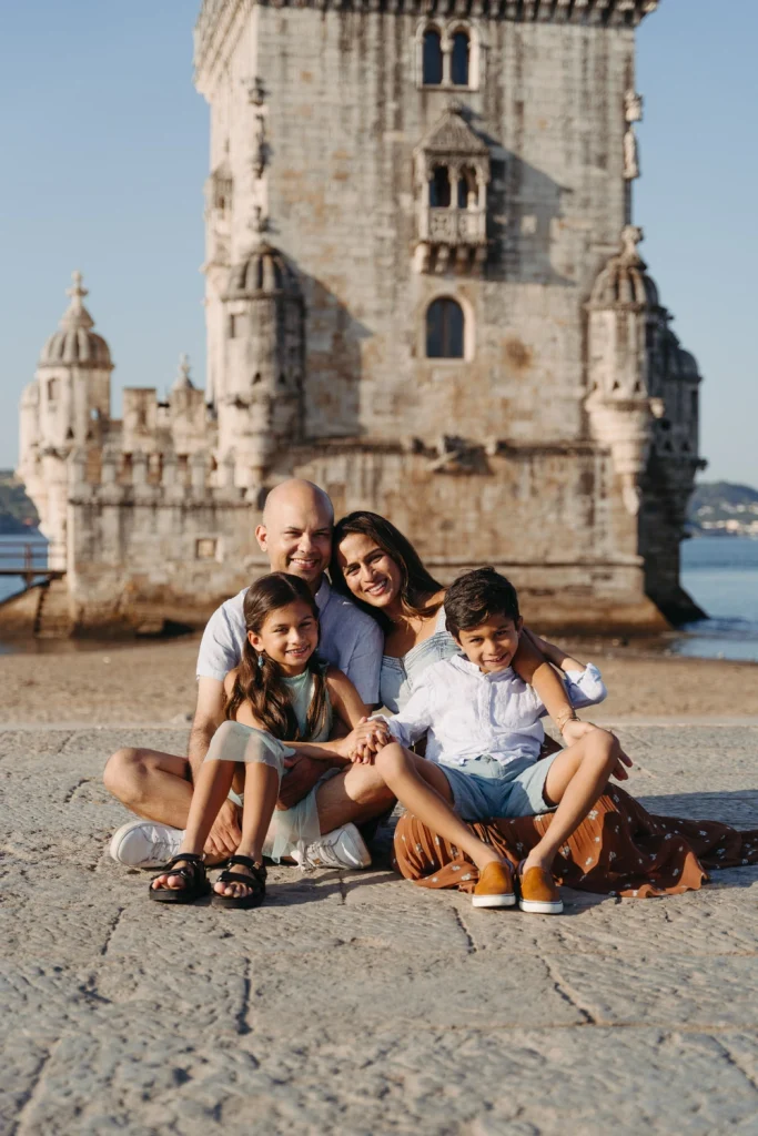 Candid moment of a family sitting together in front of Belem Tower, Lisbon, Portugal.