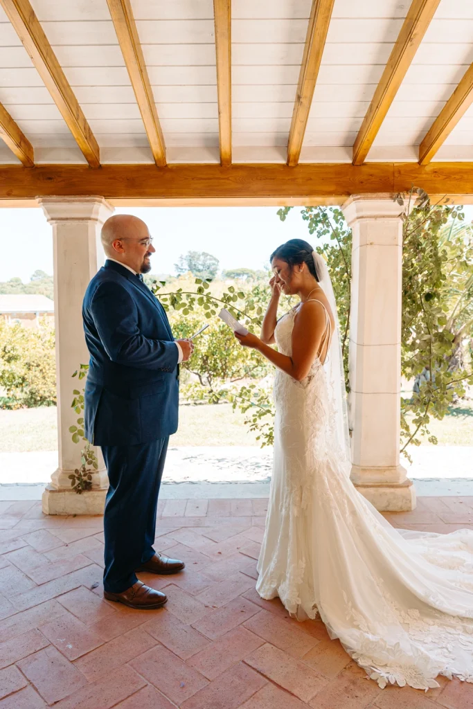 Bride wiping away tears while reading her wedding vows during a first-look moment at Quinta de Sant'Ana.