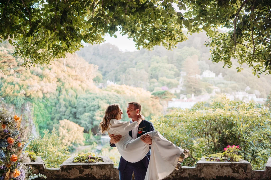 Groom lifts his bride in a romantic pose against a panoramic mountain view in Sintra photo credit Leila Ferreira Lisbon Wedding Photographer
