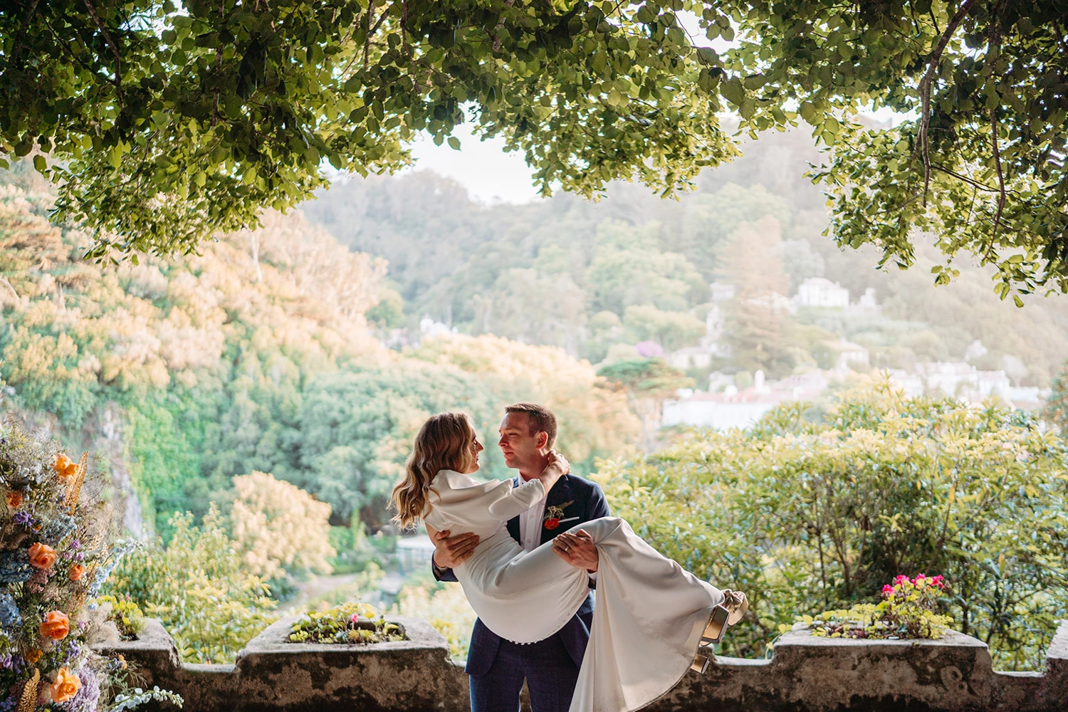 Groom lifts his bride in a romantic pose against a panoramic mountain view in Sintra photo credit Leila Ferreira Lisbon Wedding Photographer