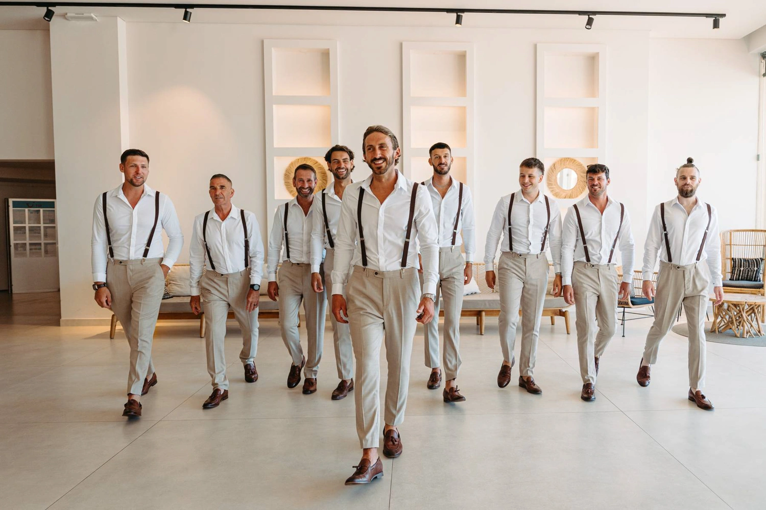 The groom and his groomsmen confidently walk together in matching black and white attire, exuding elegance and style.