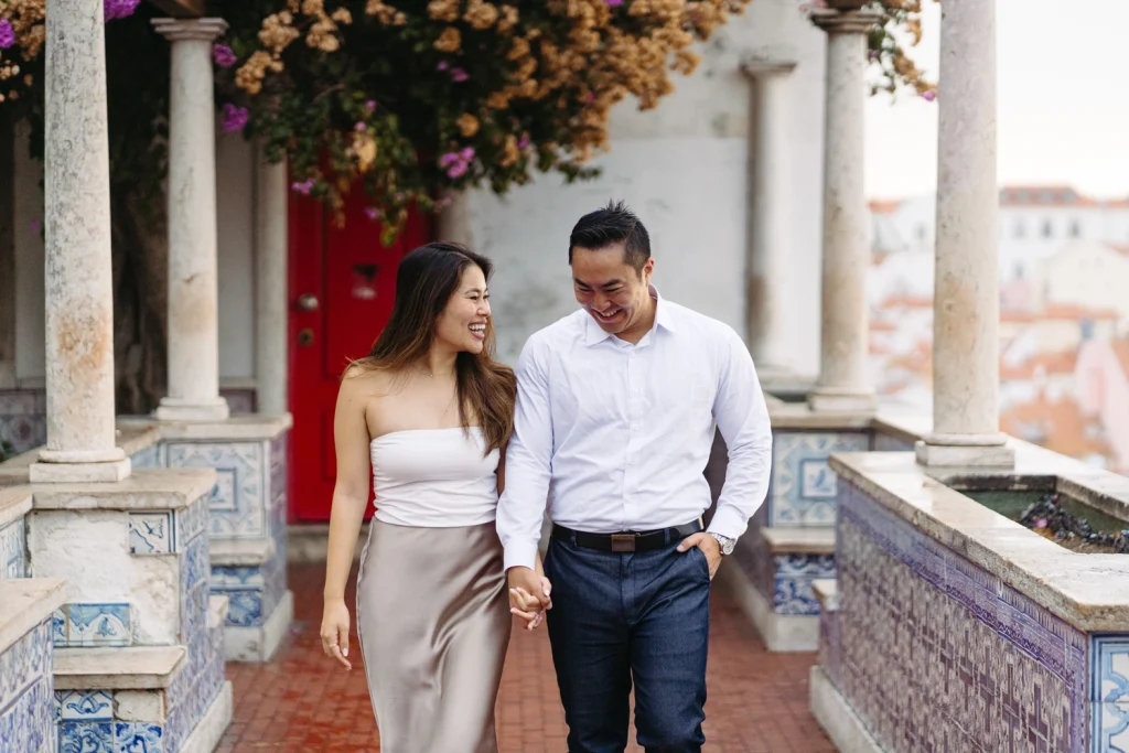 A couple embraces on a scenic Lisbon terrace, the sunset casting a golden glow over the city rooftops.