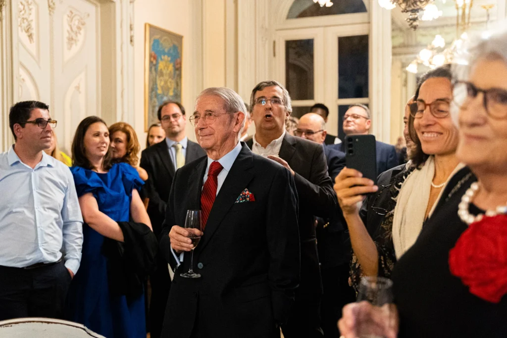 Guests mingling at an upscale cocktail reception in a beautifully decorated venue in Portugal.