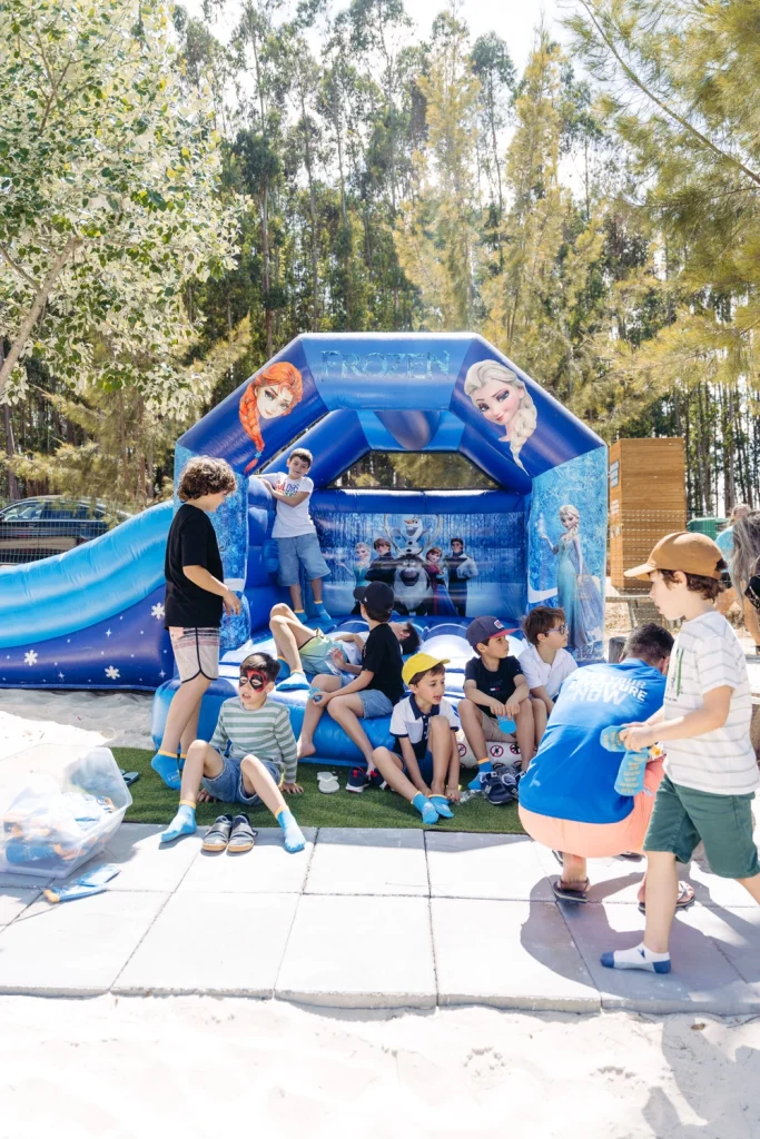 A group of children enjoying an outdoor birthday party with inflatable games and themed activities