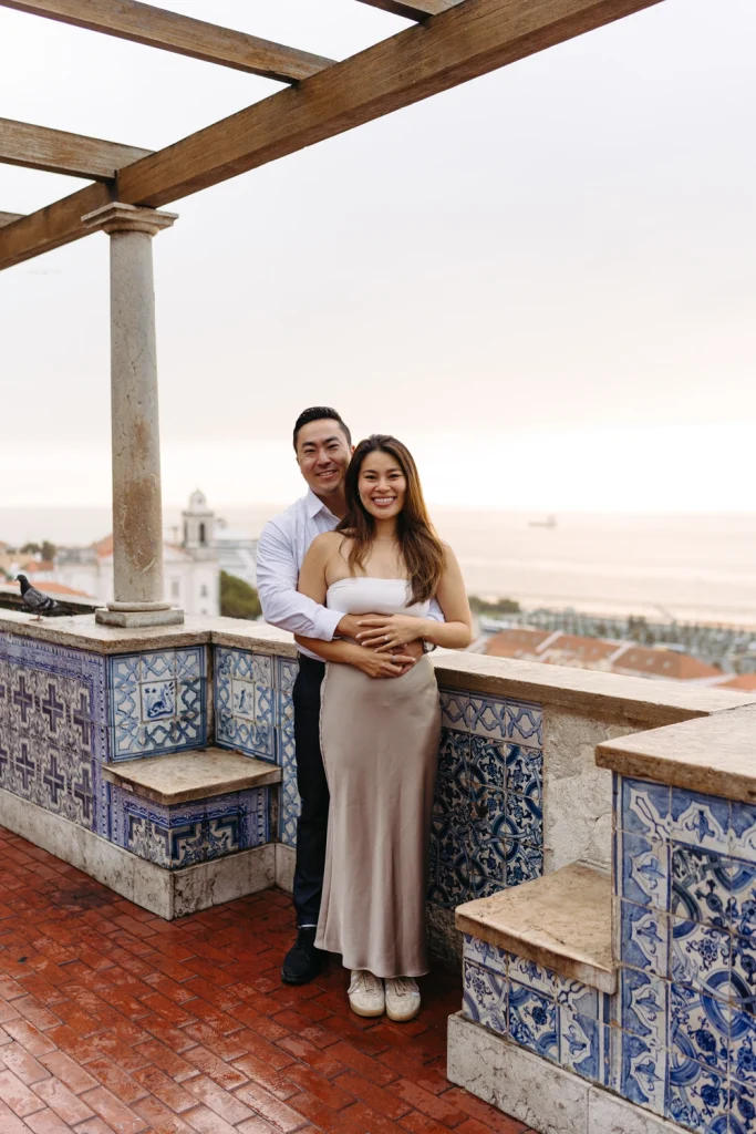 A couple playfully runs across Lisbon’s cobblestone streets, radiating love and adventure