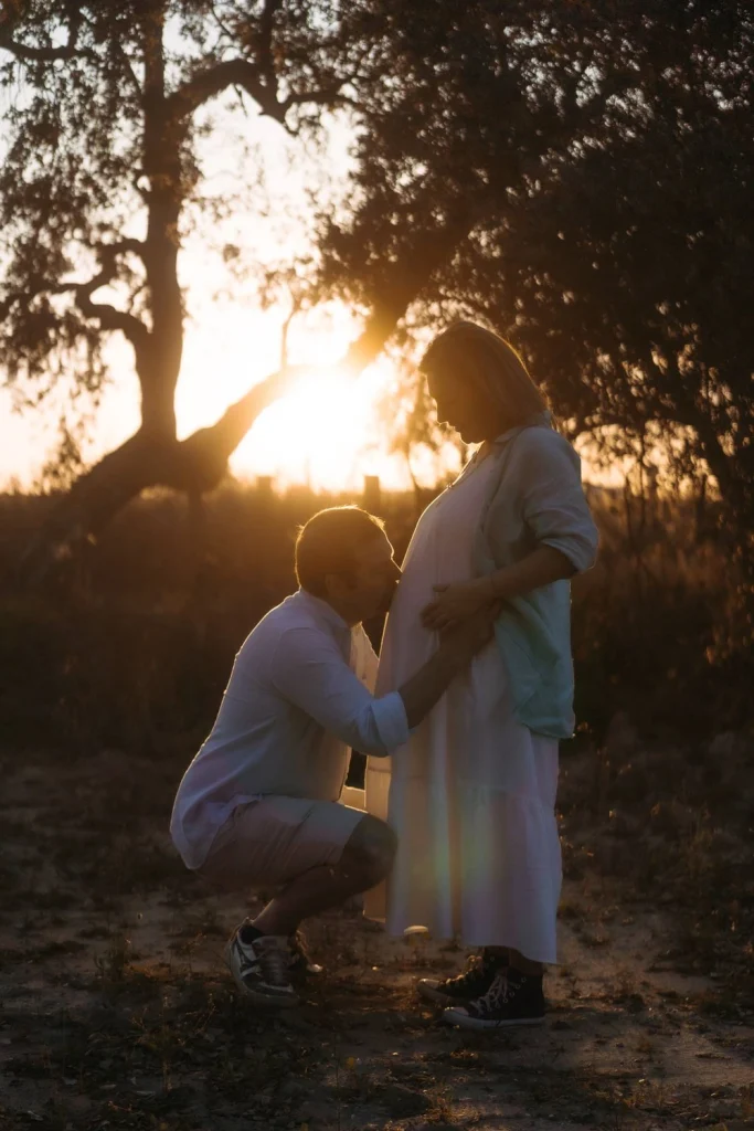 Couple embraces in a scenic outdoor maternity shoot with breathtaking mountain views.