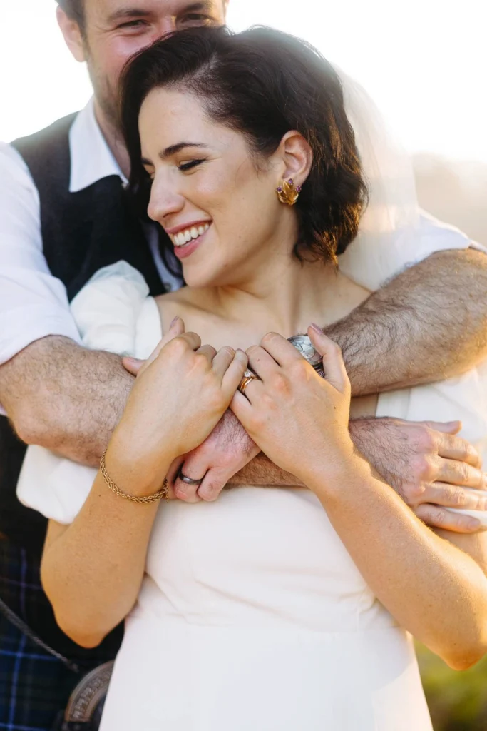 A close-up of the bride and groom in an intimate embrace, showcasing their wedding rings and deep connection in Portugal
