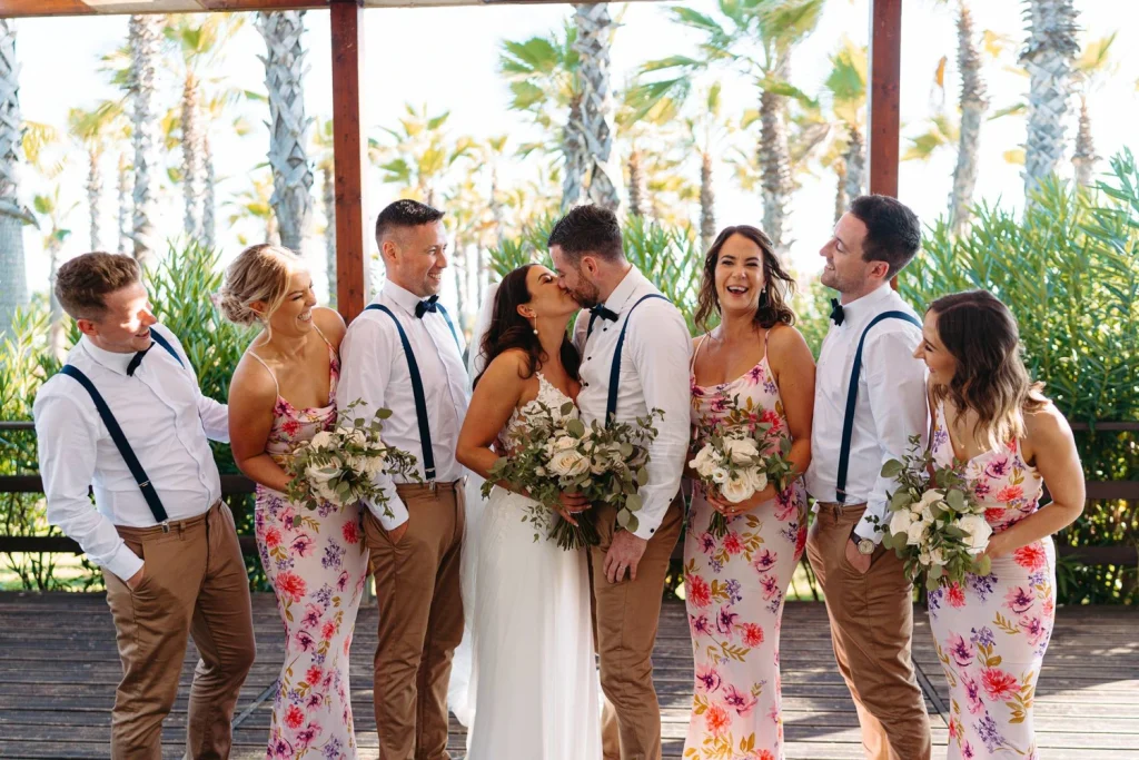 The bride and groom celebrate with their bridesmaids and groomsmen in a lively group portrait. Filename: anita-aidan-bridal-bouquet-veiling