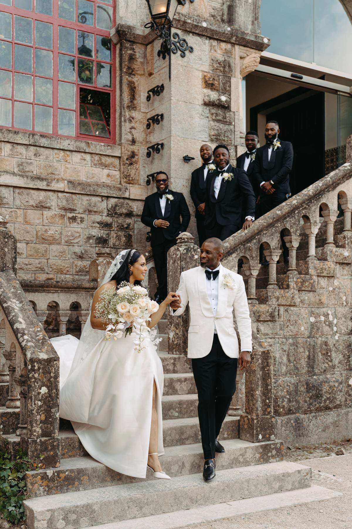 Bride and groom walking down the stone staircase at Forte da Cruz after their wedding ceremony in Estoril