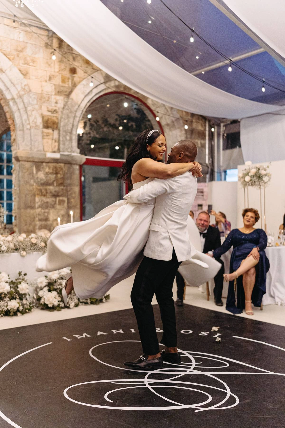 Groom lifting bride during romantic first dance at Forte da Cruz wedding reception in Estoril Portugal
