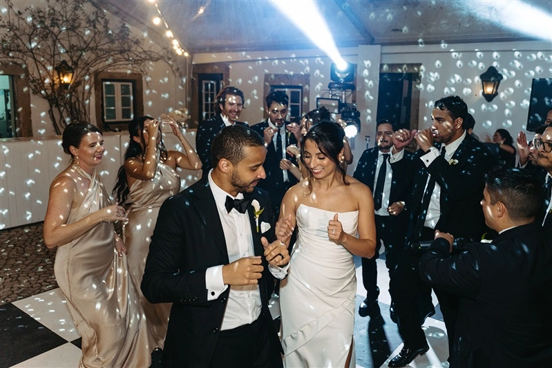 Bride and groom dancing surrounded by guests during a joyful Jewish wedding reception in Portugal