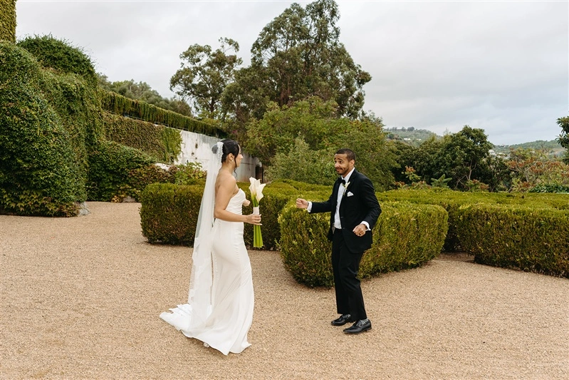 Playful bride and groom portrait in the gardens of a romantic Portugal wedding venue after their ceremony.