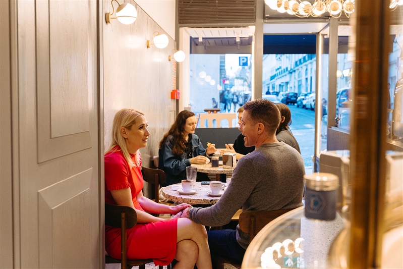 Candid couple sitting together in a charming coffee shop during a Lisbon couples photoshoot