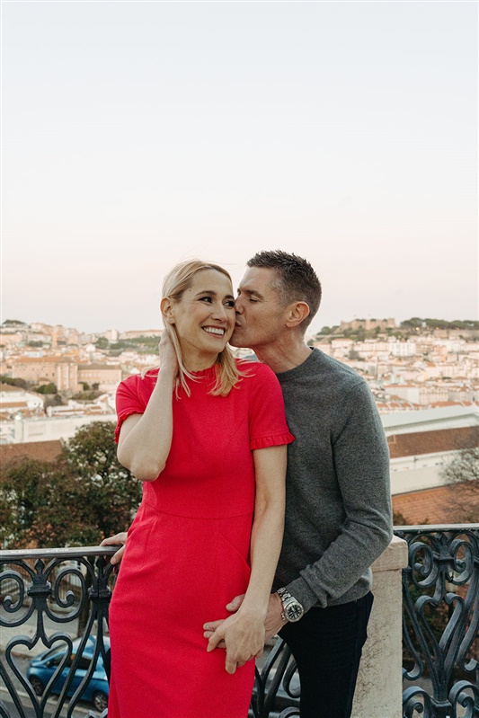 Candid portrait of a couple sharing a romantic moment with panoramic Lisbon views in the background