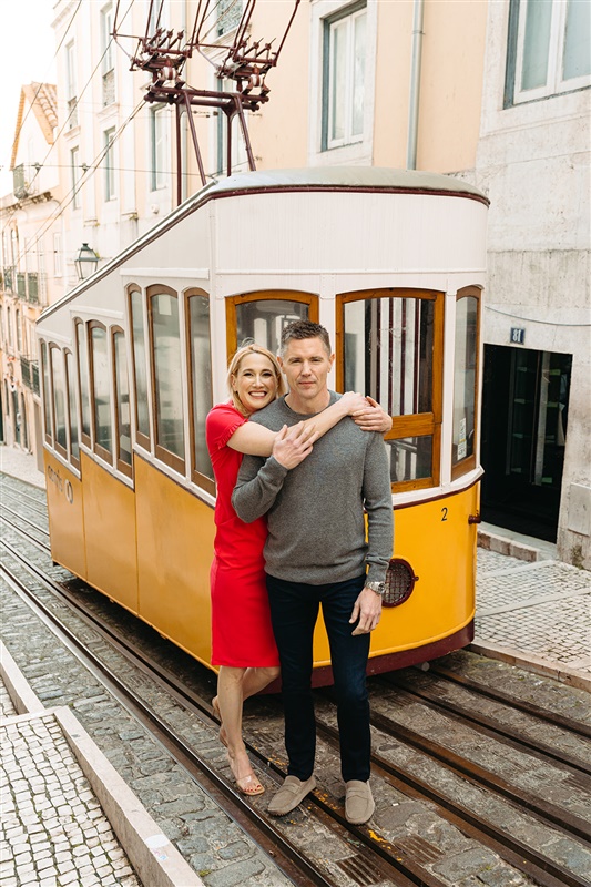 Couple posing in front of Lisbon’s iconic yellow tram during a couples photography session