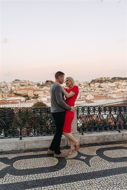 Romantic couple embracing at a Lisbon viewpoint overlooking the city at sunset