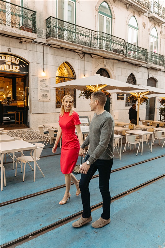 Stylish couple walking hand in hand through the charming streets of Lisbon during a romantic photo session
